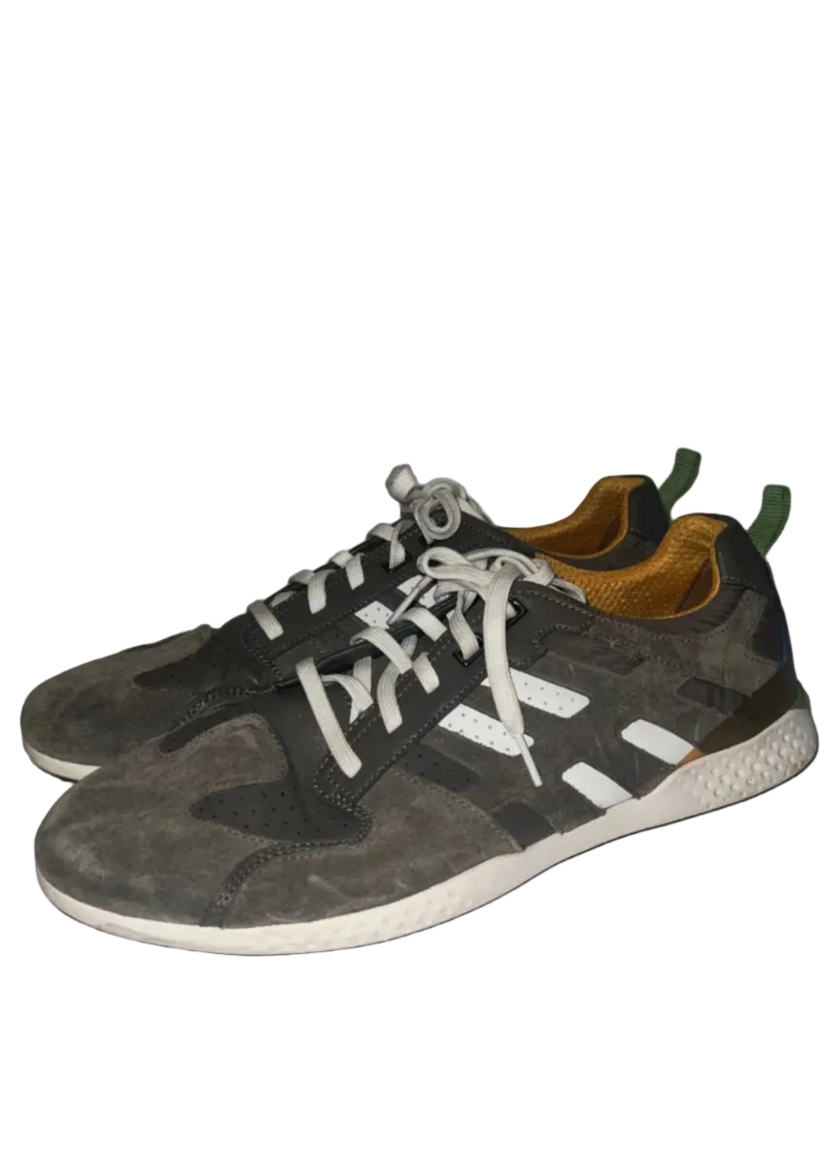 A pair of low-top athletic sneakers in dark gray suede and mesh with white laces, white side stripes, and a white sole, photographed on a white surface against a white background.