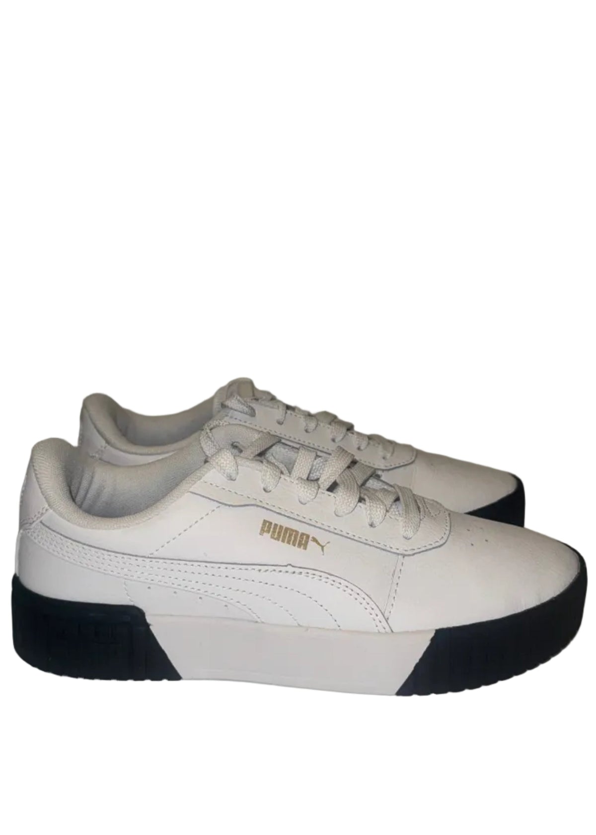 A pair of white Puma platform sneakers with black midsoles and gold branding